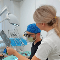 Doi membri ai echipei analizând o radiografie